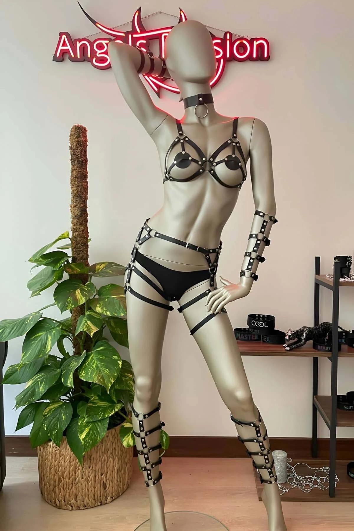 Multi-strap black faux leather thigh garters wrapping from upper thigh to mid-calf with riveted junctions