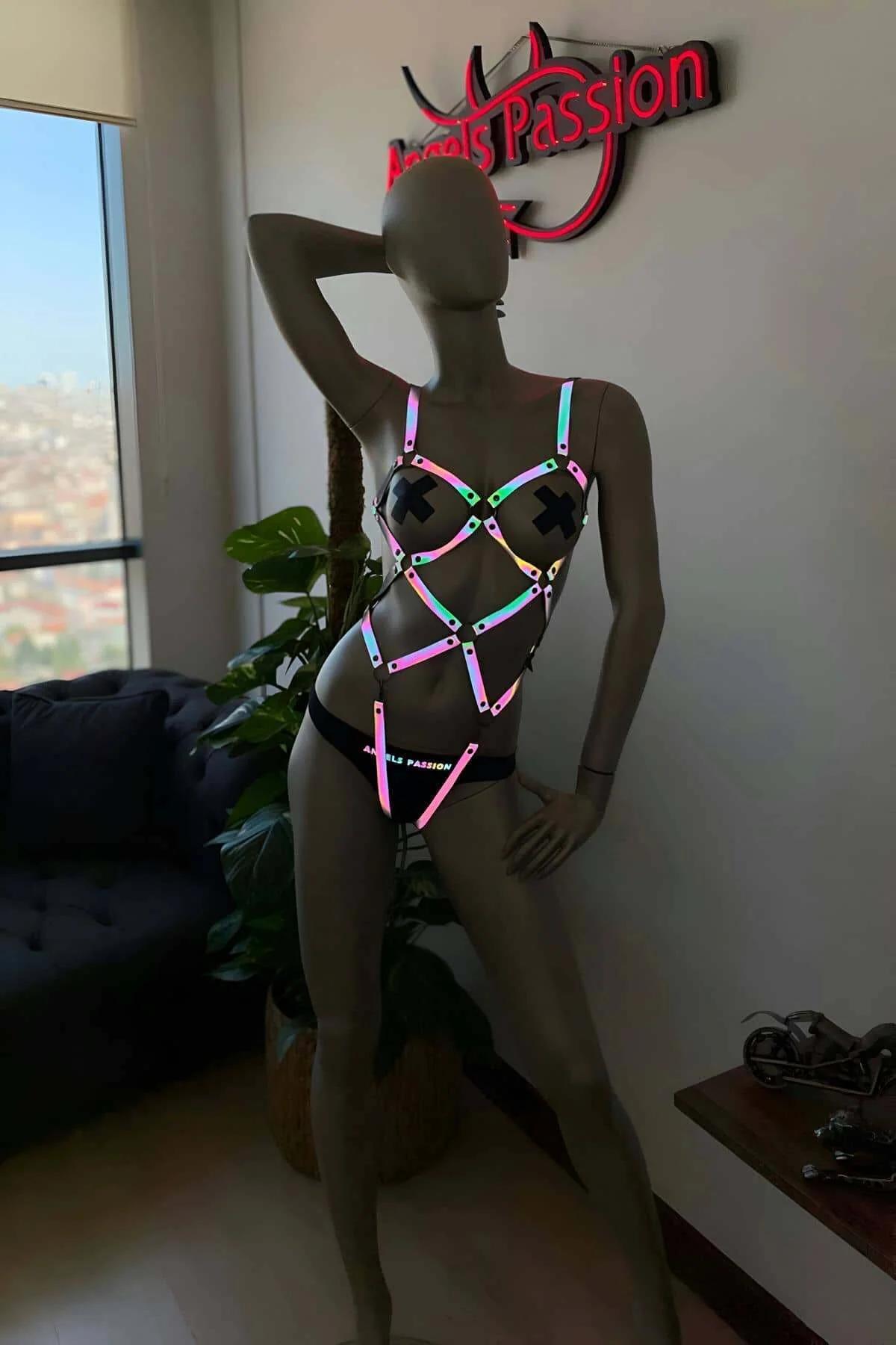 Close-up of black metal O-ring connector and holographic reflective strap texture on body harness