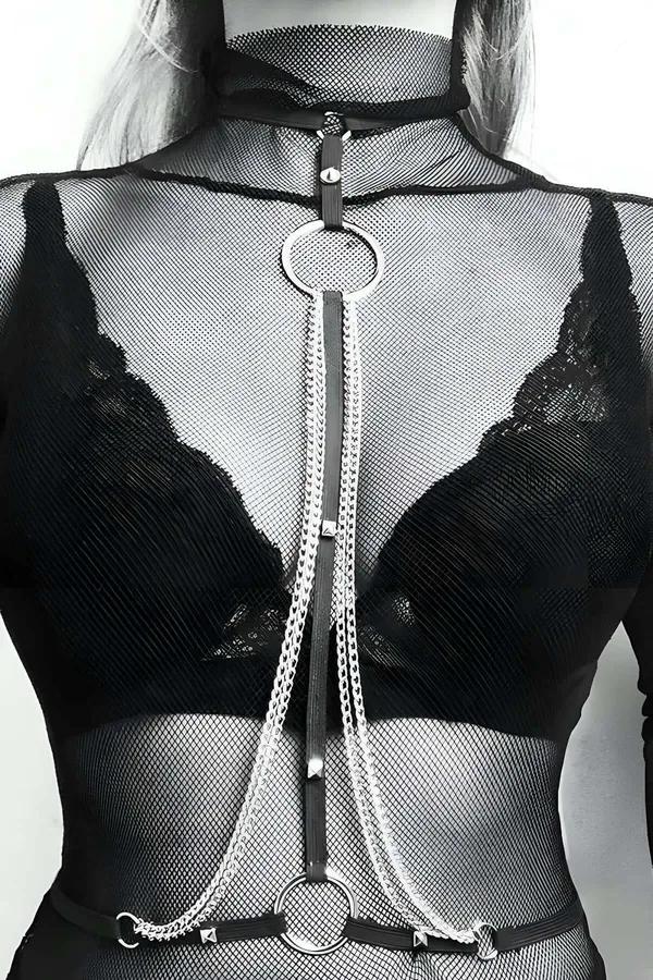Black faux leather choker chest harness with layered silver chains and metal studs worn over black lace bra