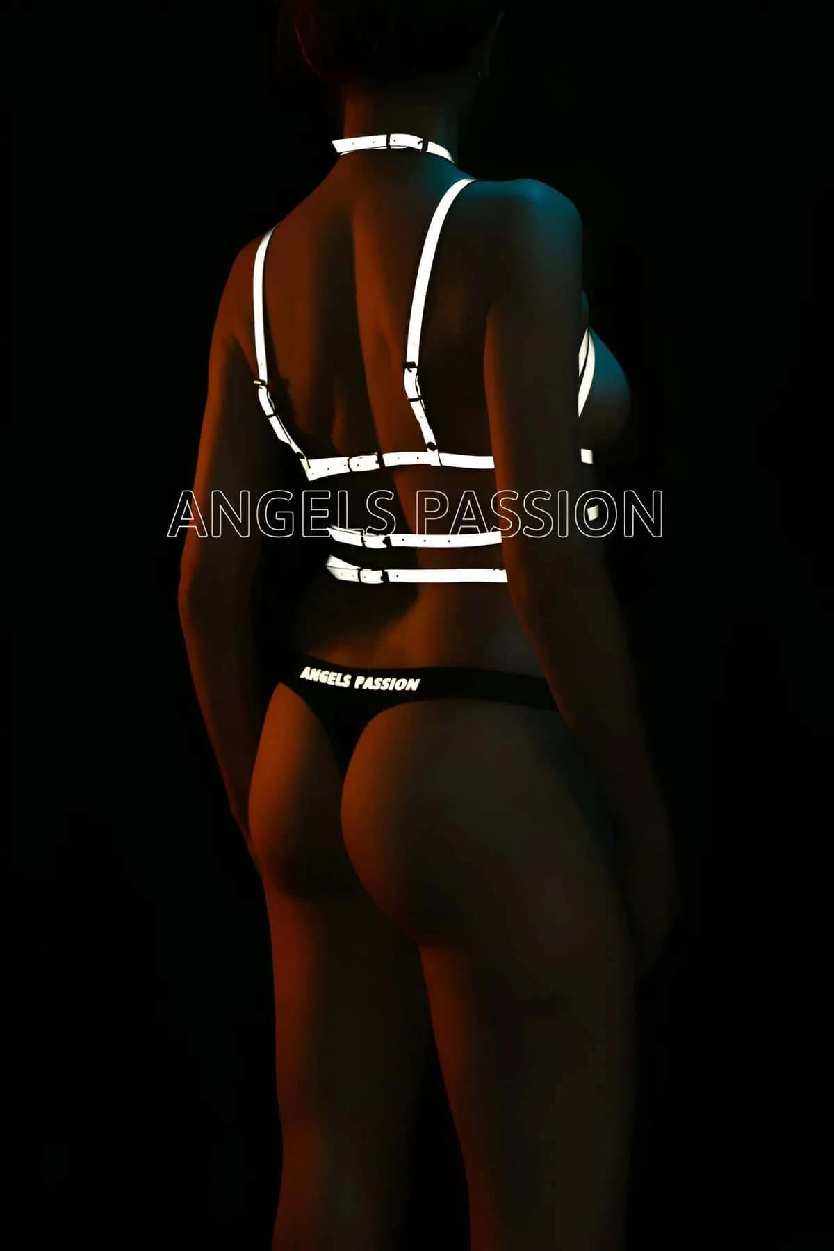 Geometric cage harness with adjustable silver slider buckles on white reflective straps against dark background