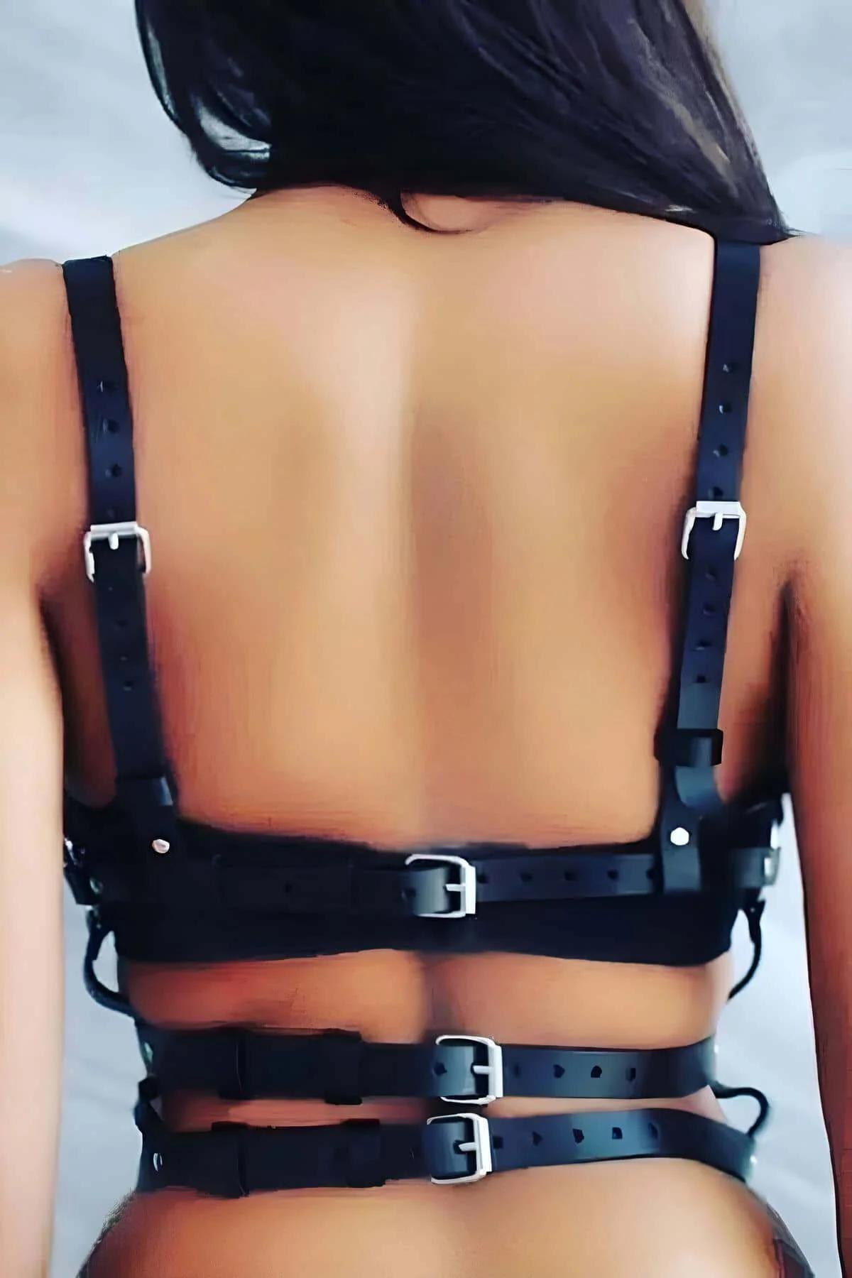 close-up of silver rivet studs along center sternum panel on black faux leather harness