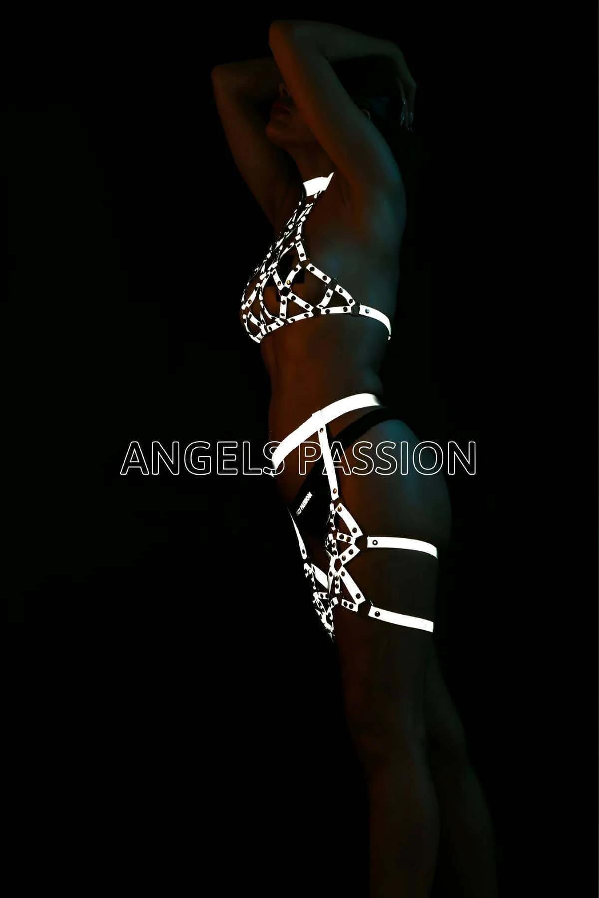 Full set flat lay of white-silver reflective harness pieces: halter, waist band, and garter pair
