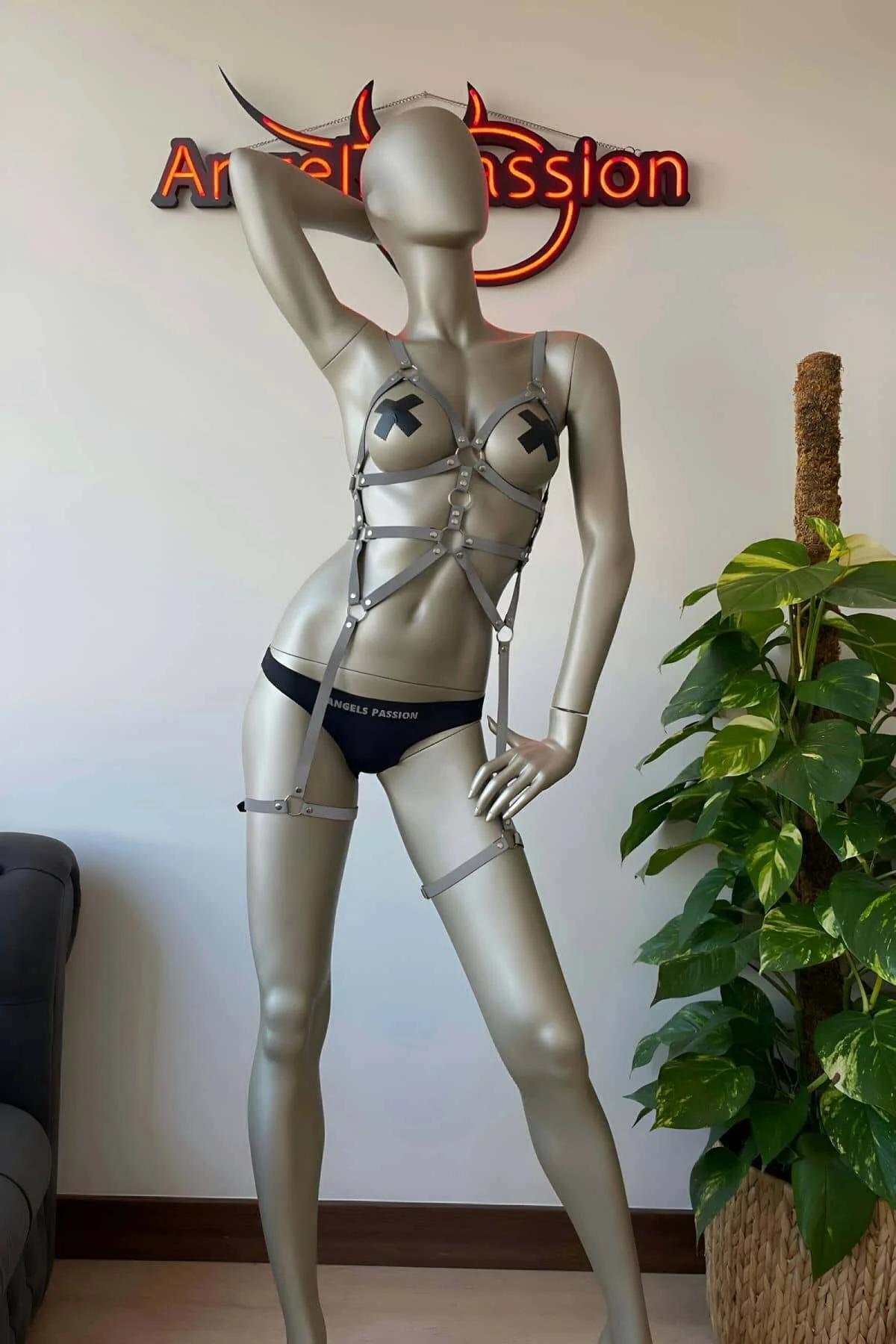 Reflective multi-strap harness laid flat on dark surface showing complete geometric strap configuration and adjusters