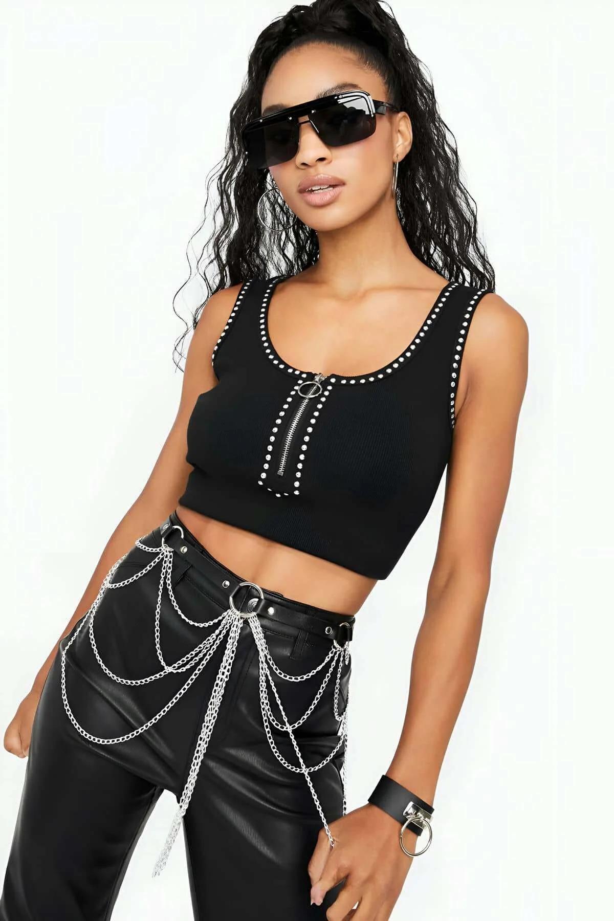 Close-up of silver oval-link chains and O-ring hardware on black faux leather belt harness