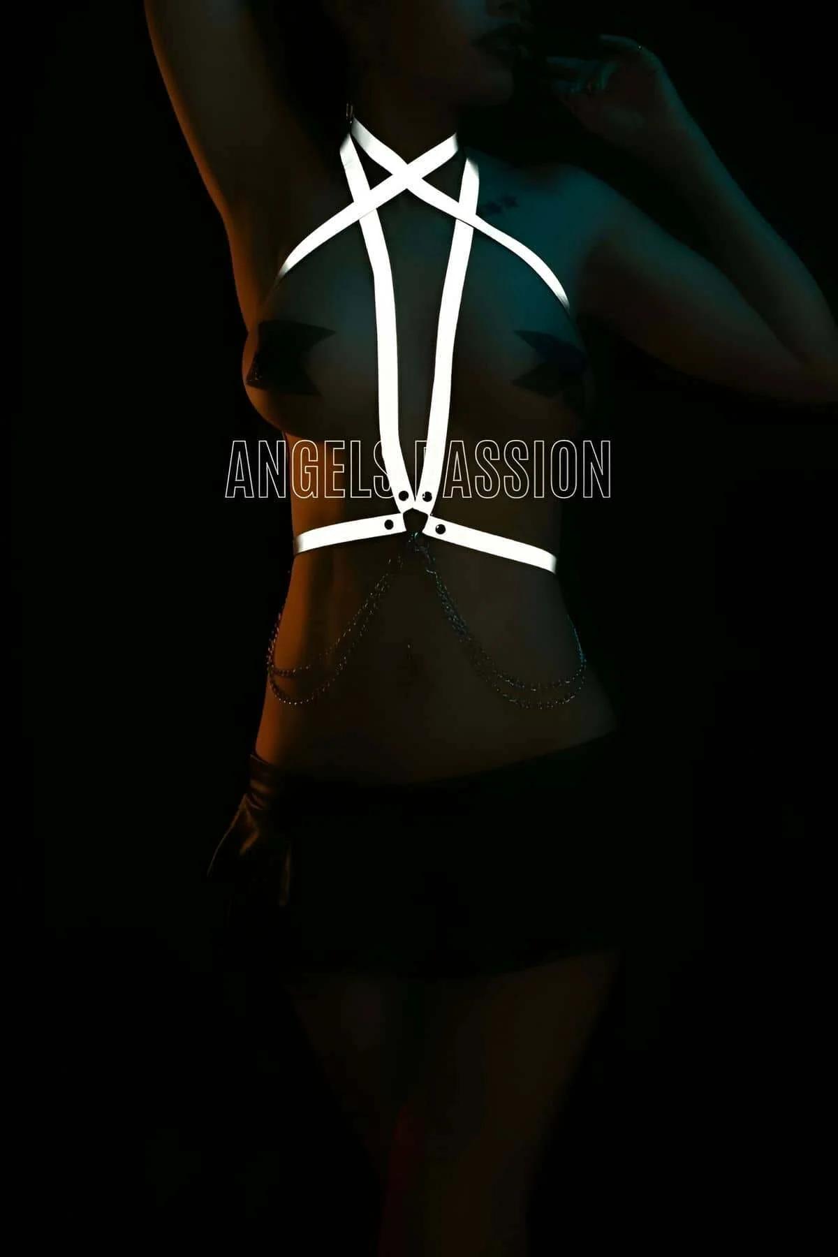 Reflective body harness waist band and decorative chain accent close-up in low-light setting