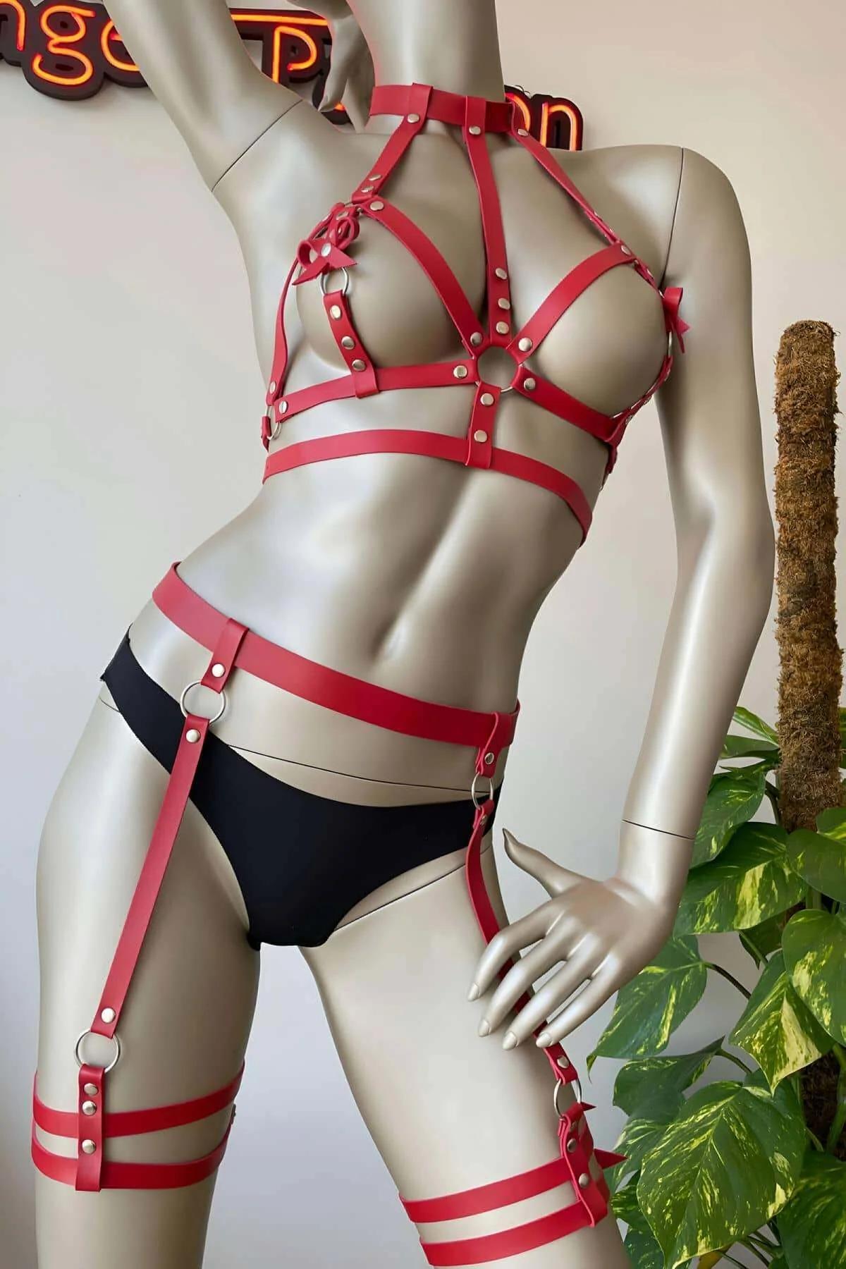 Double-strap red faux leather thigh cuff with silver pin buckles on mannequin leg