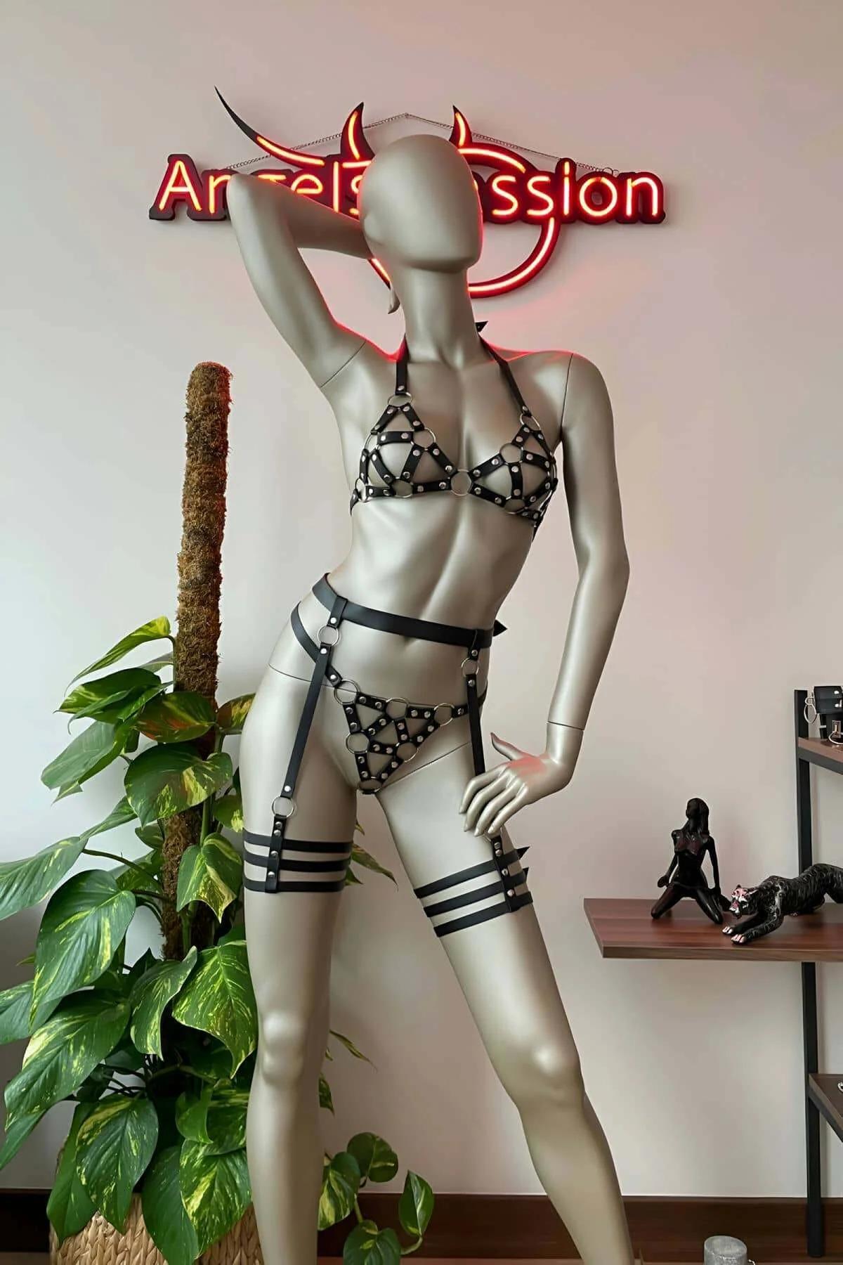 Black faux leather cage bra harness top with triangular strap panels and silver rivet studs