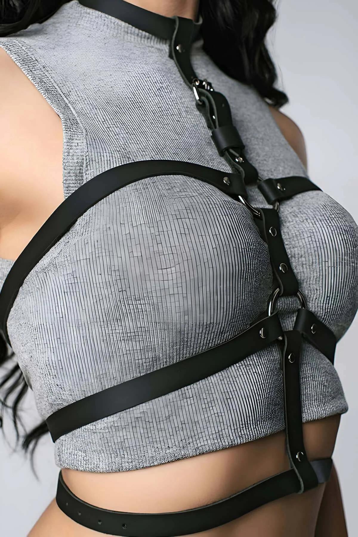 Front view of black faux leather cage harness showing dual chest straps and gold buckle hardware