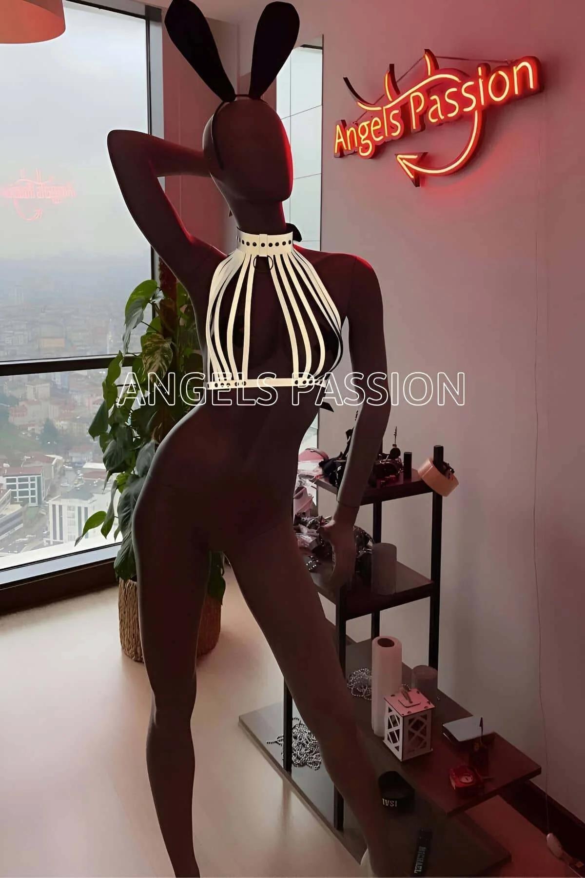 Side profile of reflective strappy halter top with O-ring neck worn over black trousers