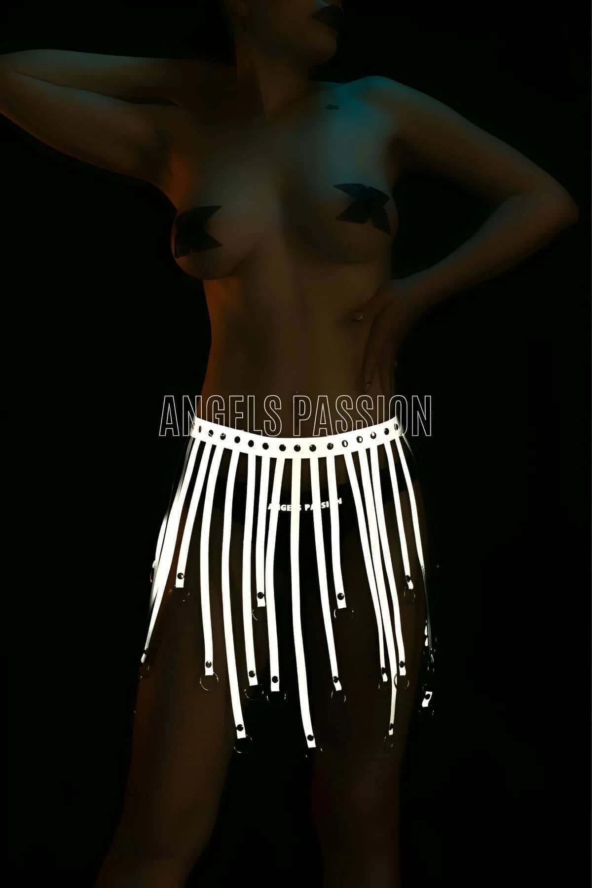 Close-up of white retroreflective faux leather tassel straps with silver O-ring finishes on body harness
