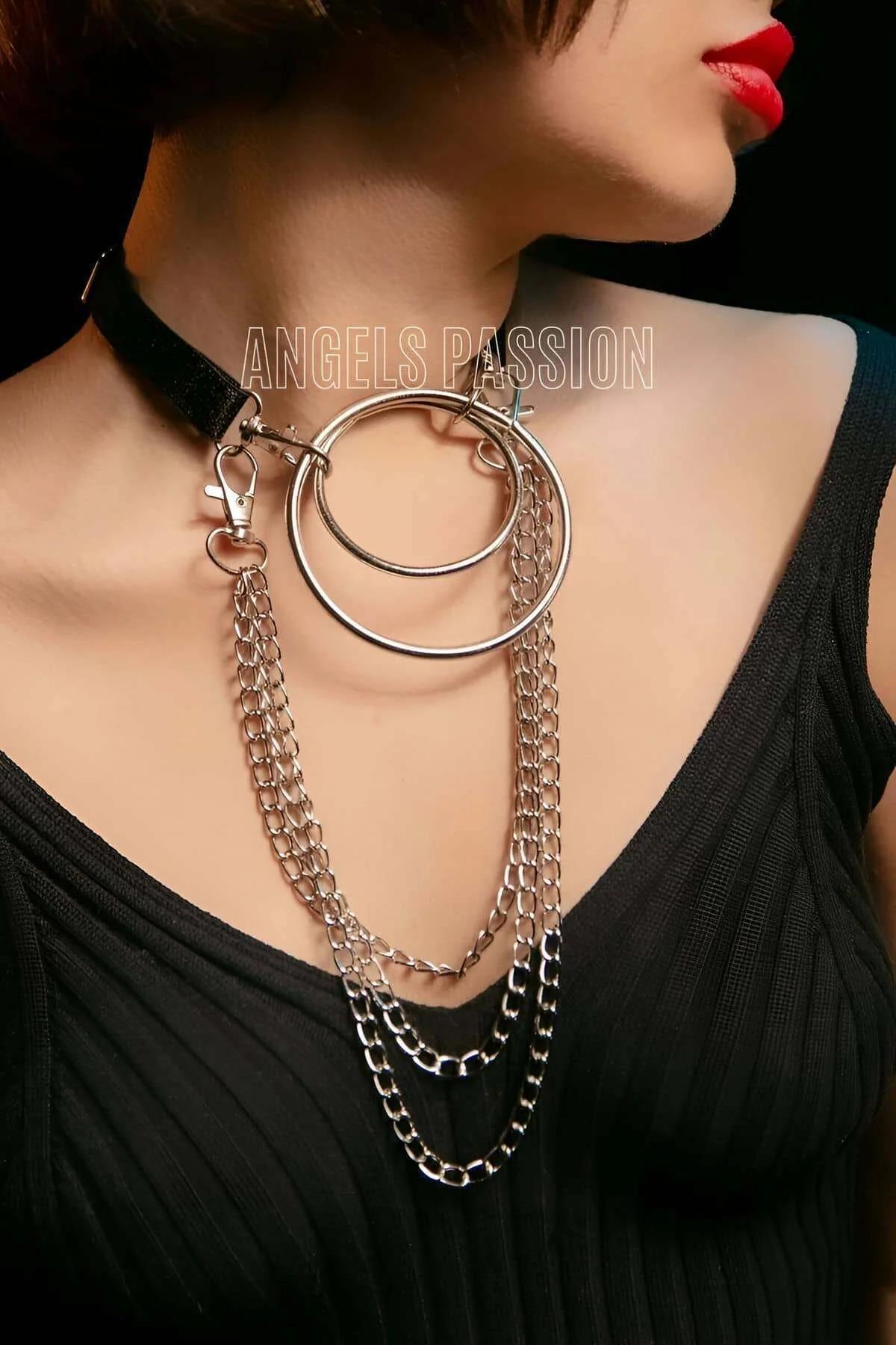 Close-up of dual stacked silver-tone O-rings on black wide choker band against skin