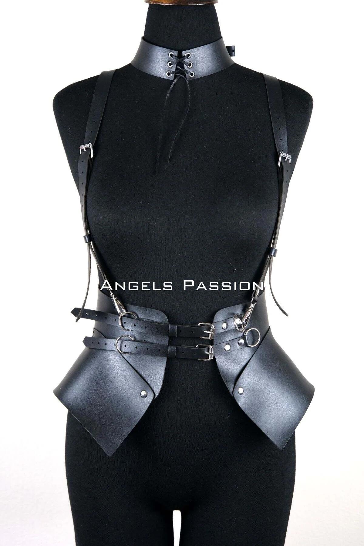 Full-length view of black structured harness with side panels layered over fitted white bodysuit
