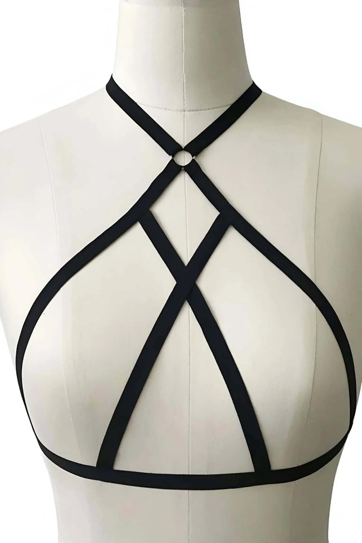Geometric angular strap configuration of black body harness across chest and shoulders