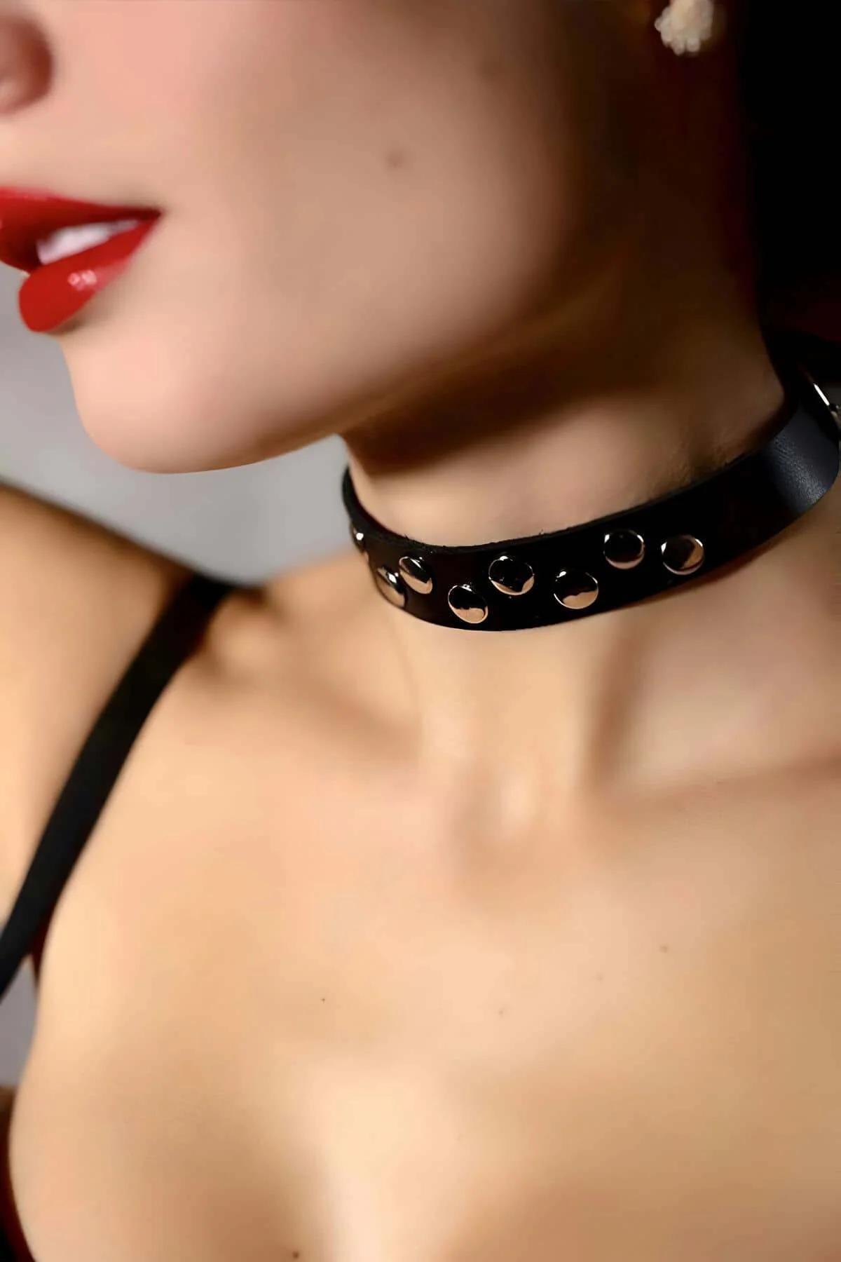 Close-up of gunmetal square buckle and punched eyelets on black PU leather choker strap
