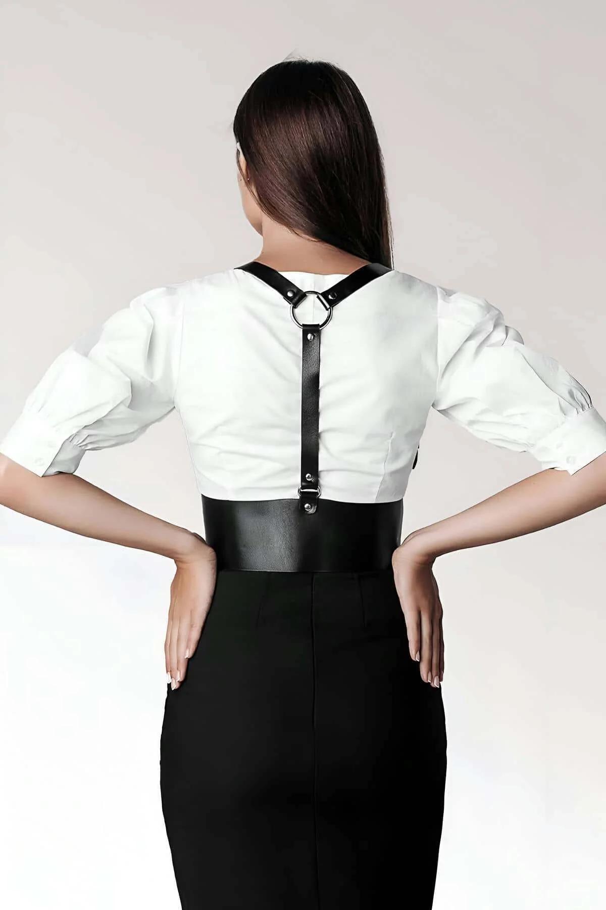 silver pin-buckle on black faux leather shoulder strap of corset harness
