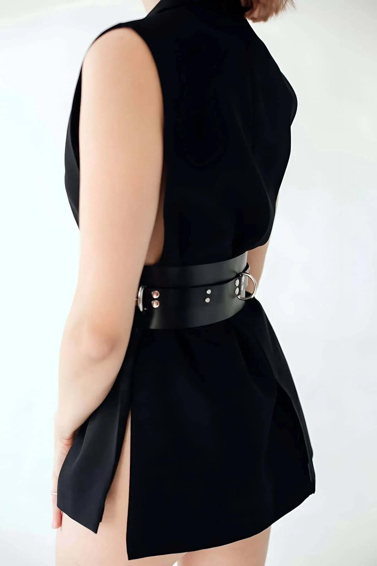 Back view of wide black faux leather waspie belt with synthetic lining detail and belt tip finish