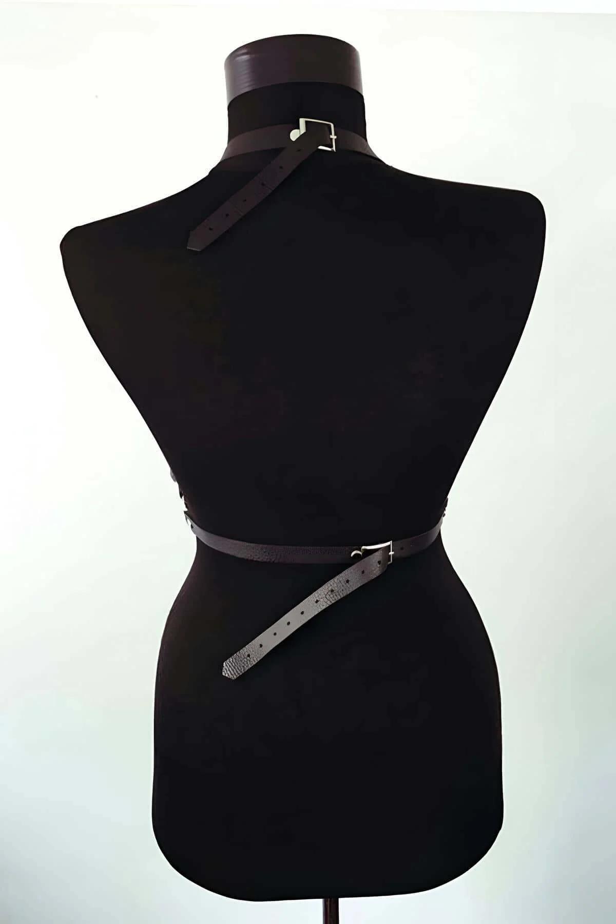 close-up of silver O-ring and stacked waist bands on black PU leather body harness