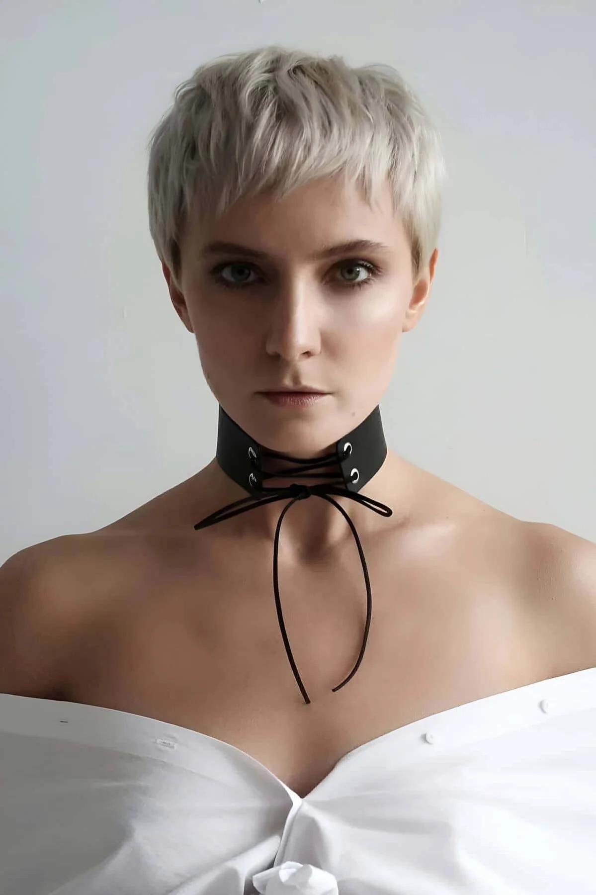 Flat lay of black wide choker with adjustable rope tie ends spread out showing full collar length
