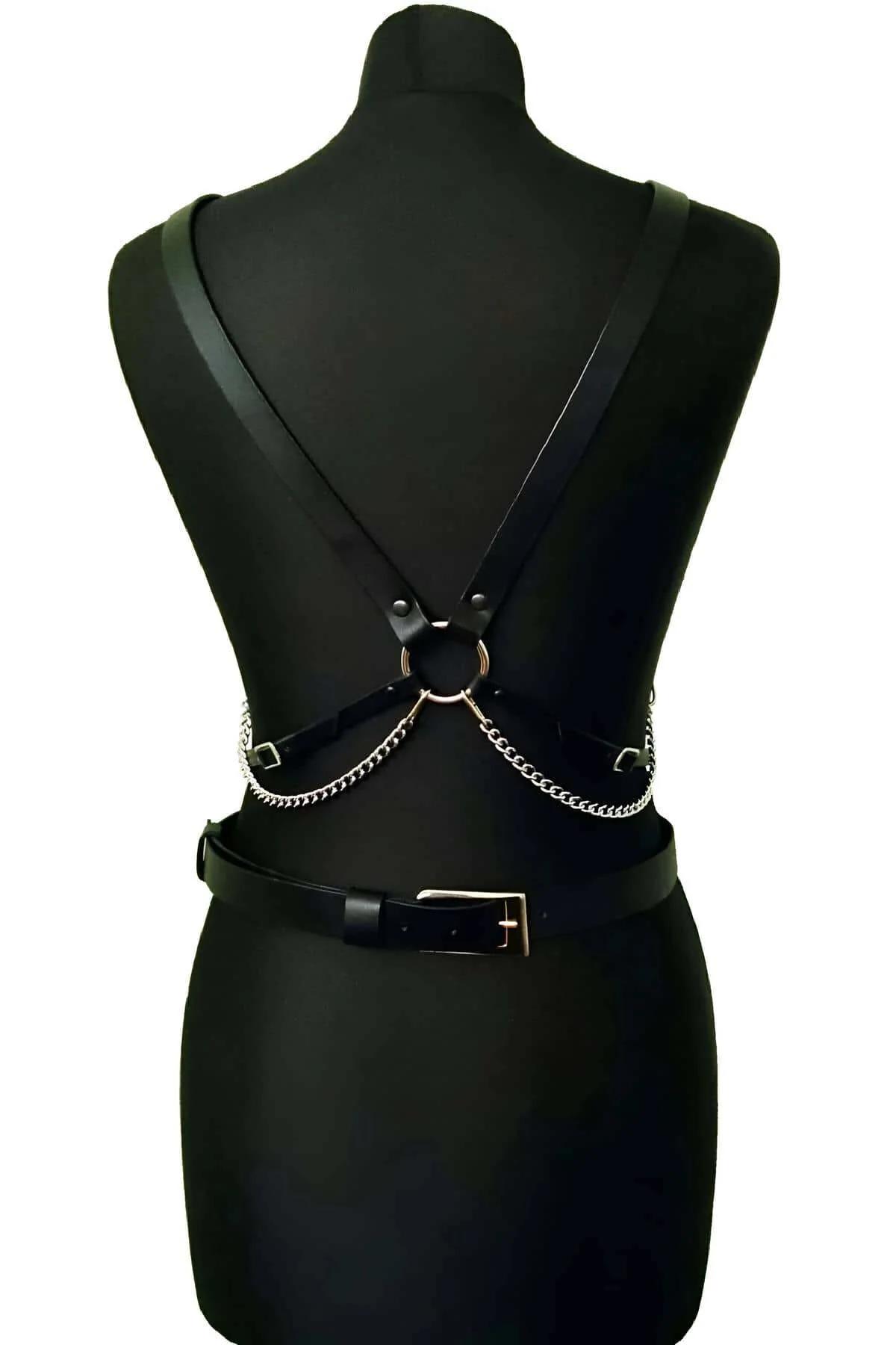 silver chain bridge connecting chest harness to waist belt on black mannequin