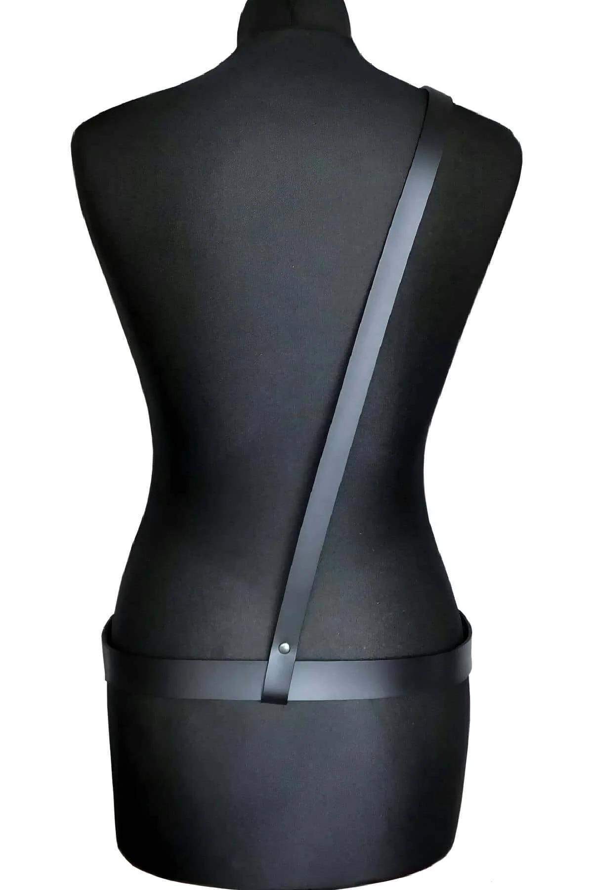 Minimalist black body harness worn over dark base layer, full torso front view