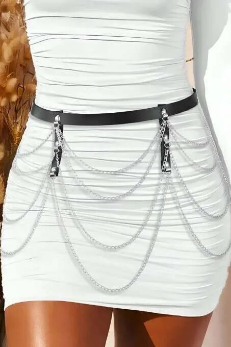 Black faux leather belt with four layered silver chains draped across front worn over white dress