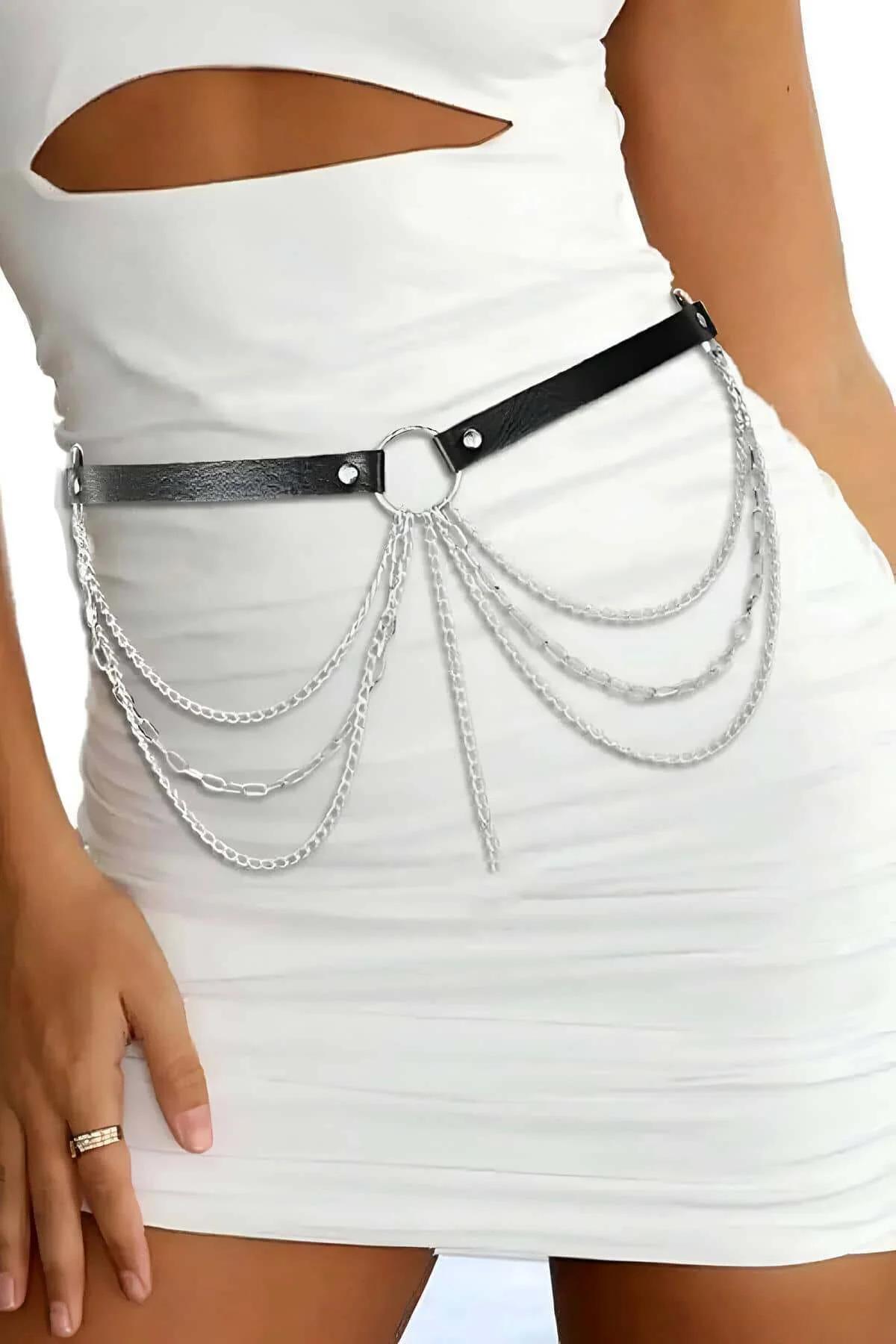Detail of pointed spike drop pendant at center of layered silver chain belt