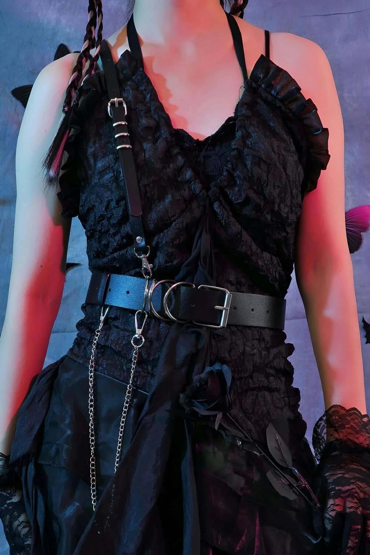 Detachable silver-tone chain hanging from D-ring on black faux leather waist belt