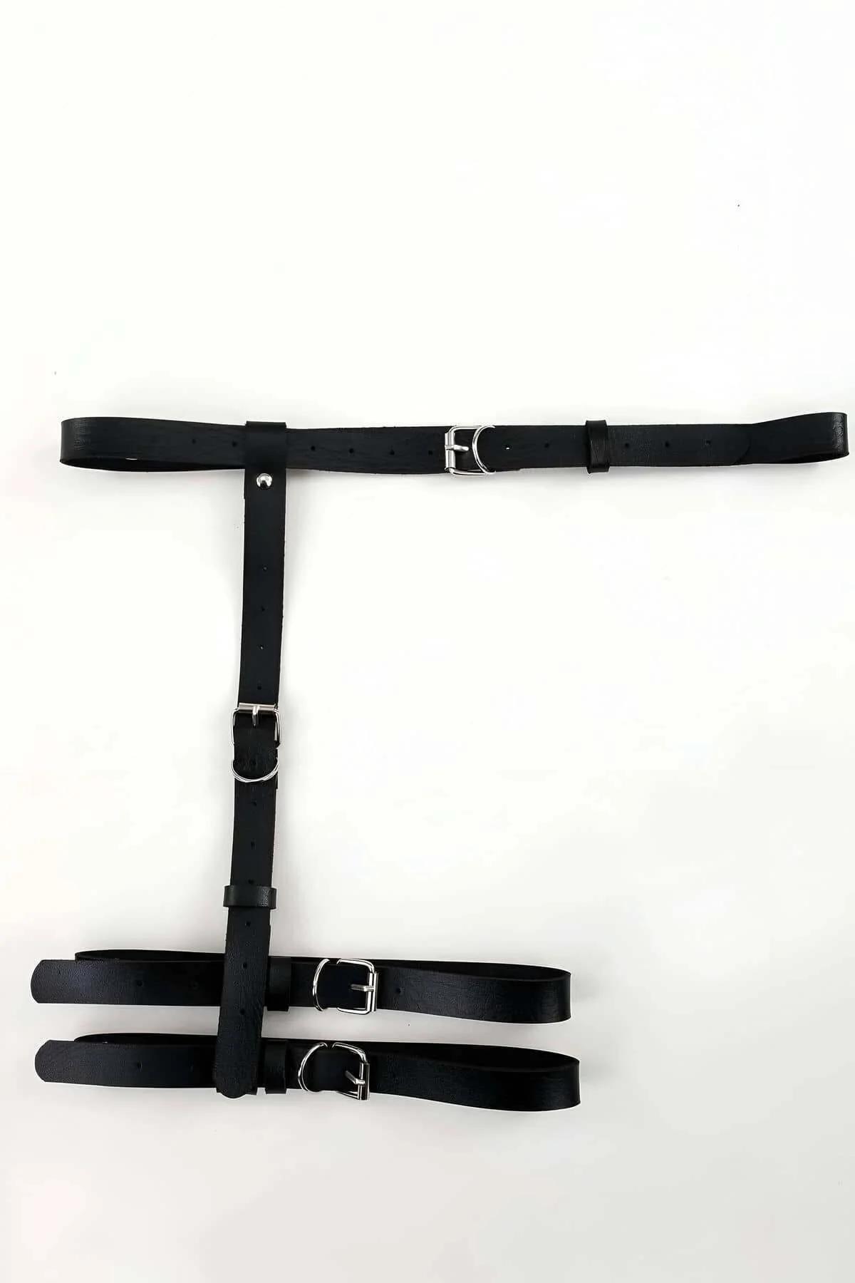 Matte black thigh harness vertical drop straps with punch-hole adjustment over light denim