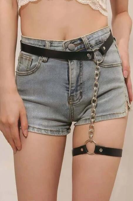 close-up of silver oval-link chain connecting black faux leather waist belt to thigh garter band