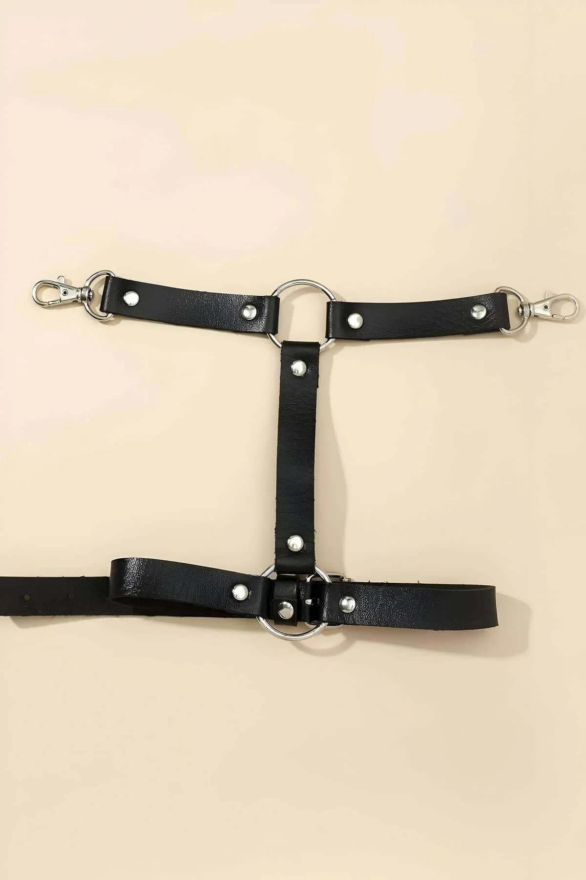 Close-up of silver trigger snap belt loop clips on black PU leather single leg harness strap