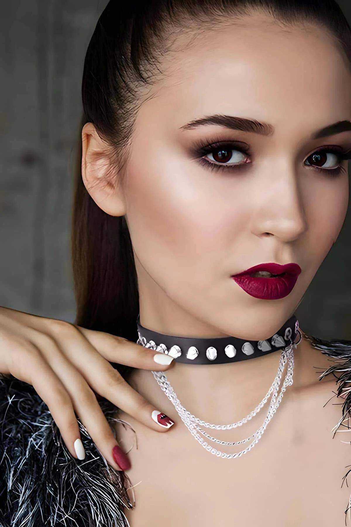 Close-up of silver cone spikes evenly spaced on black PU leather choker band
