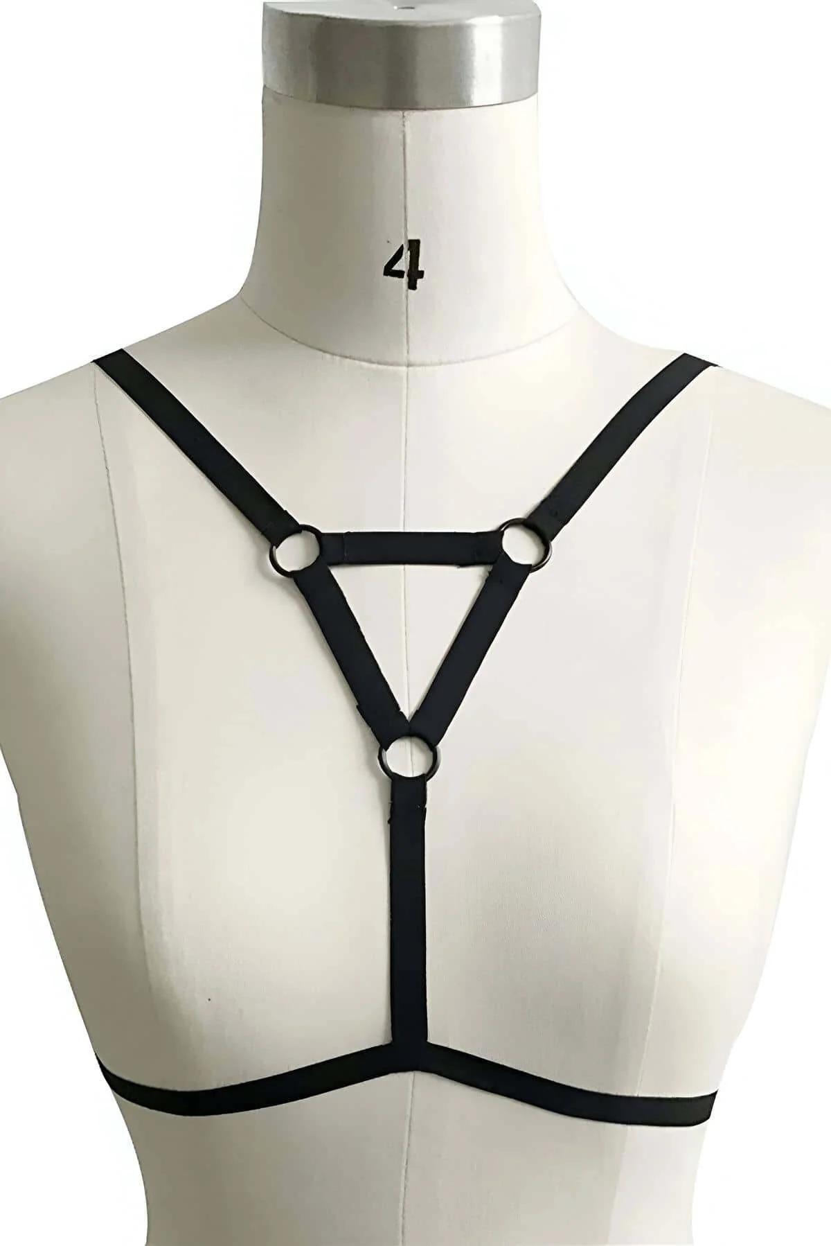 close-up of matte black O-ring hardware detail on black elastic chest harness triangle junction