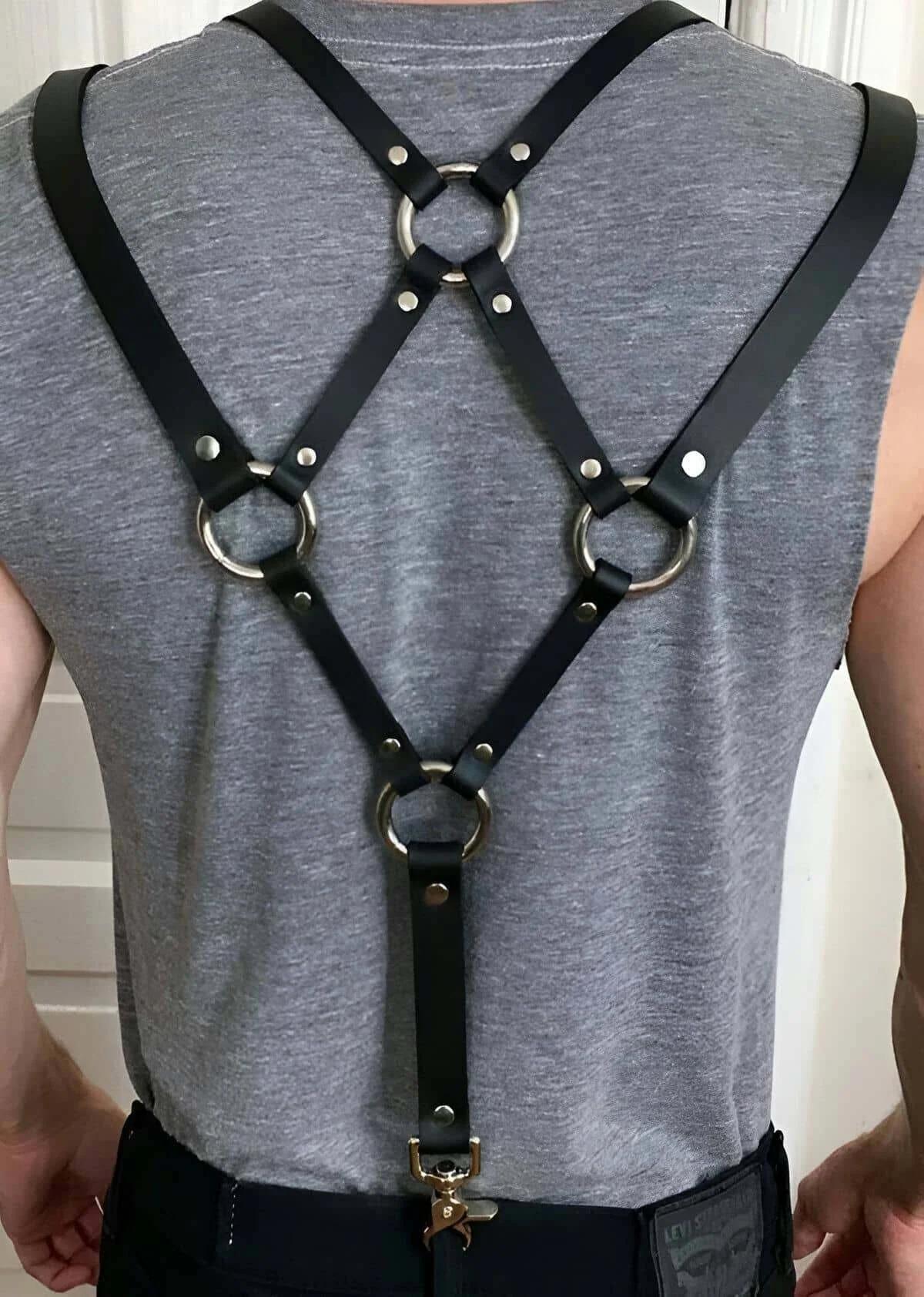 Close-up of silver O-ring junction and rivet detail on black PU back harness strap