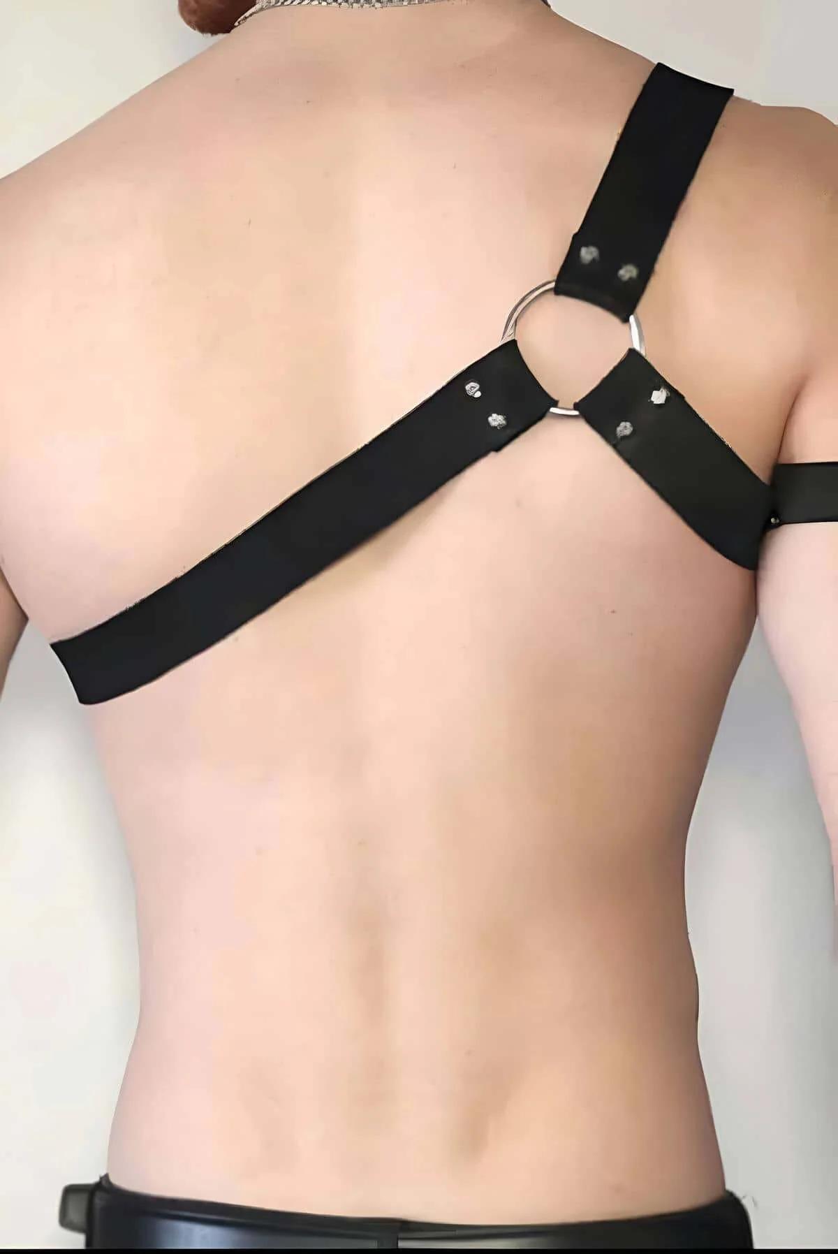 Close-up of five graduated silver O-rings on black faux leather shoulder strap with dome rivet detail