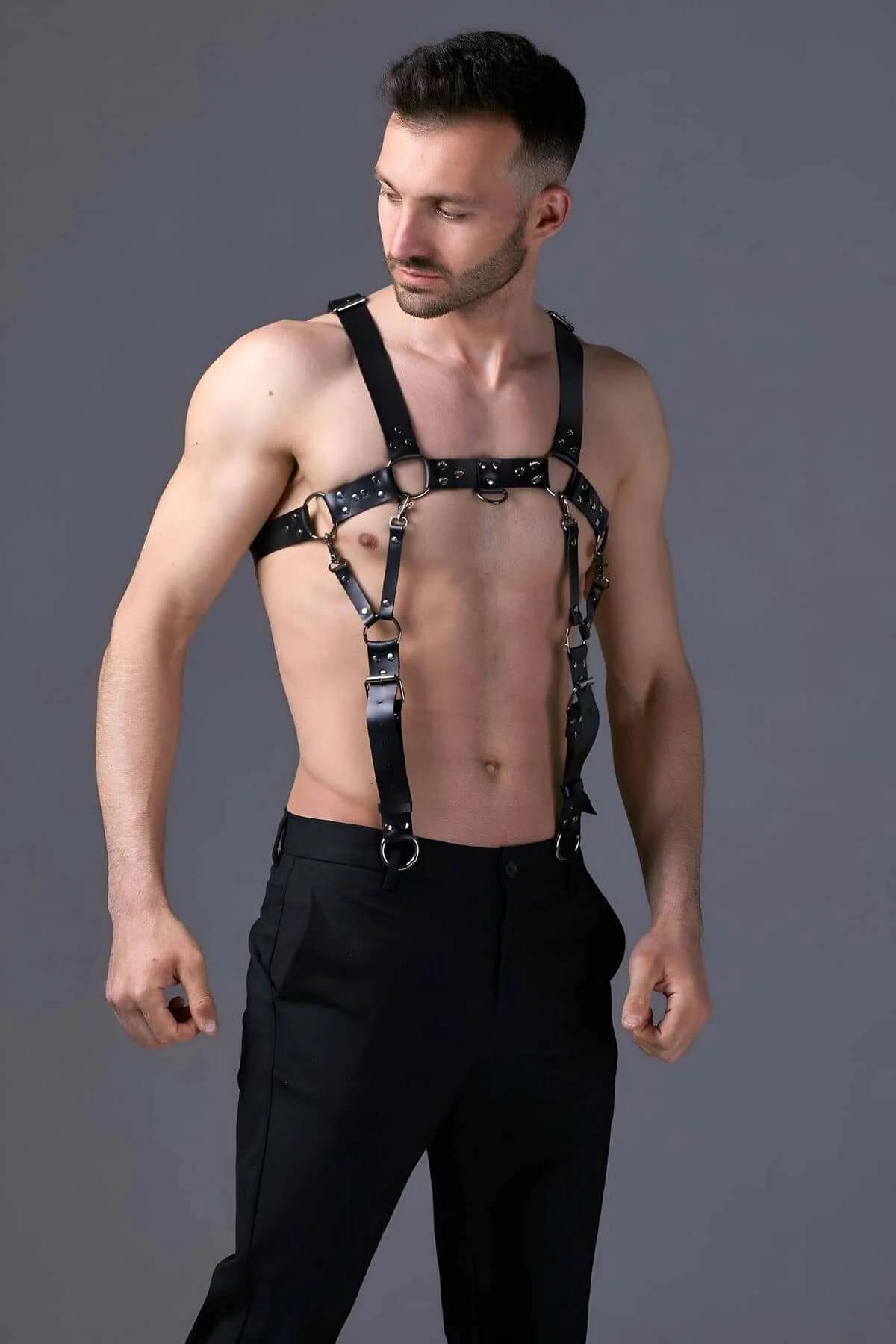 Black mens chest harness lower band with 20 mm gold hip-clip O-rings clipped to trouser loops