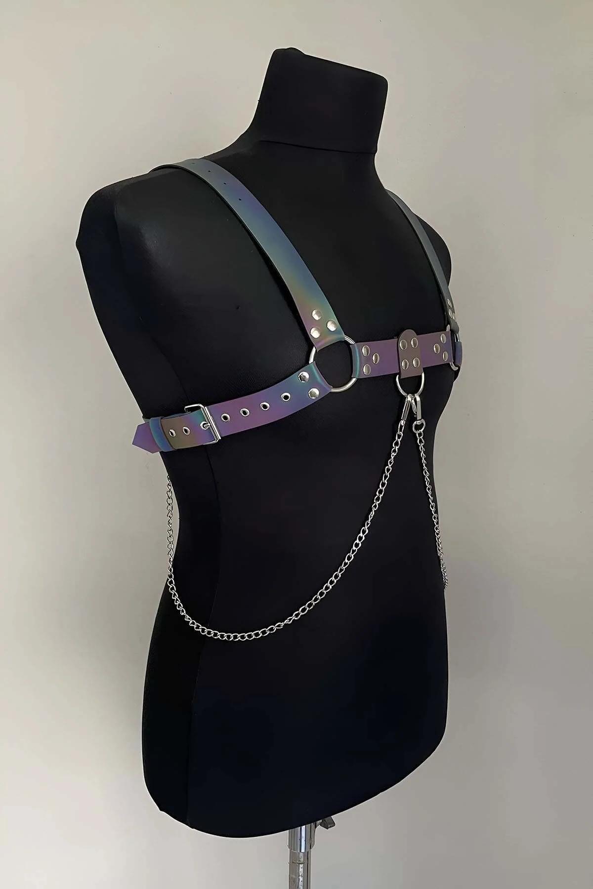 Front center O-ring detail with draped silver chain loops hanging from rainbow iridescent harness