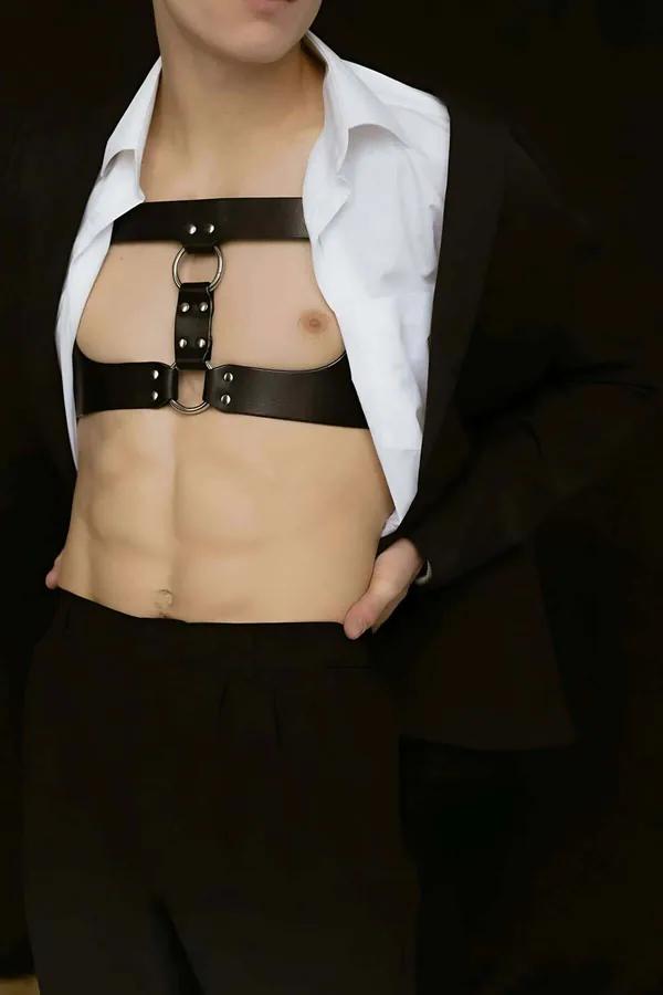 Brown faux leather dual-band chest harness with three silver O-rings worn over open white shirt
