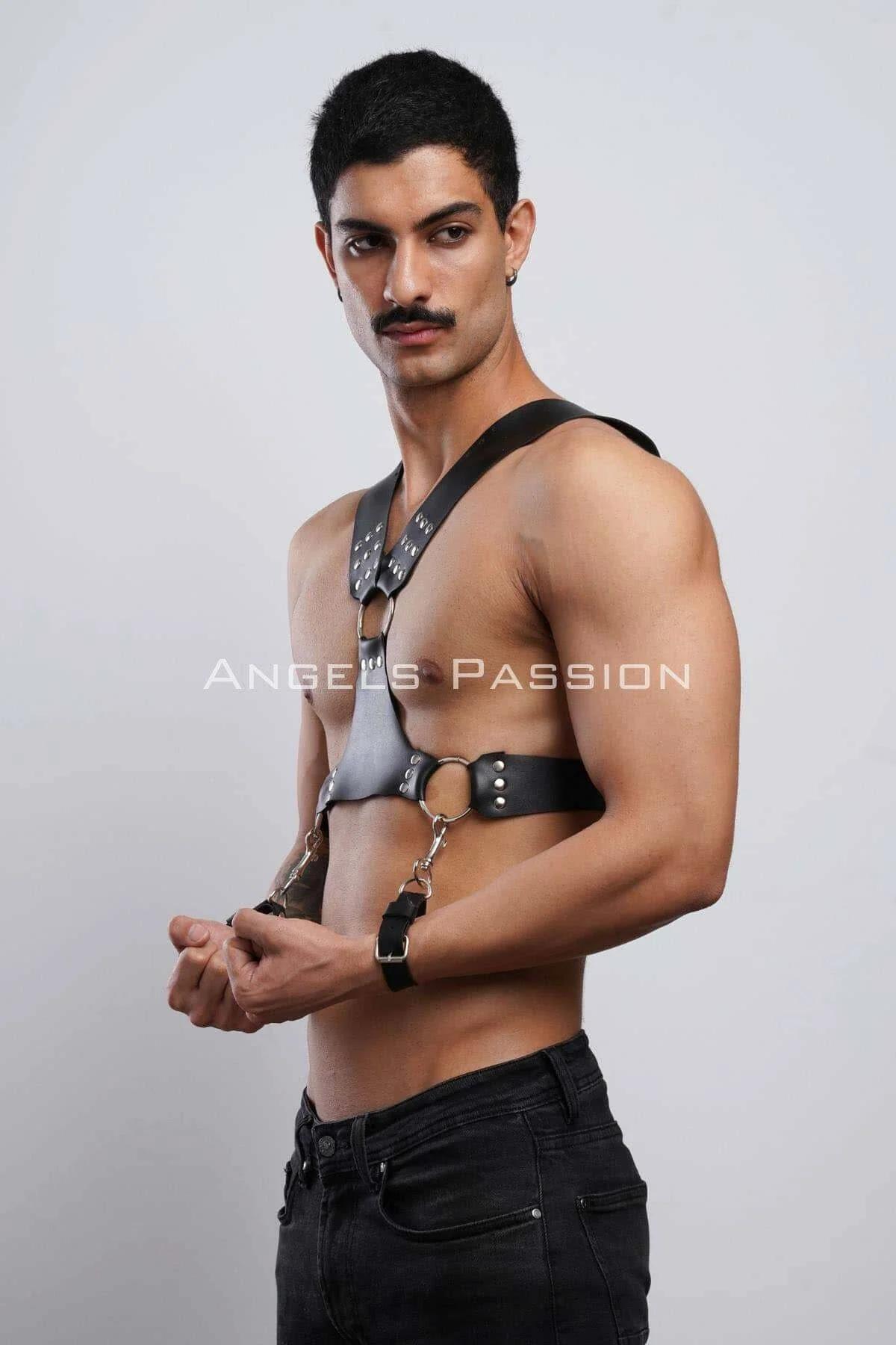 Black studded chest harness snap-hook connector detail joining wrist cuff to waist O-ring