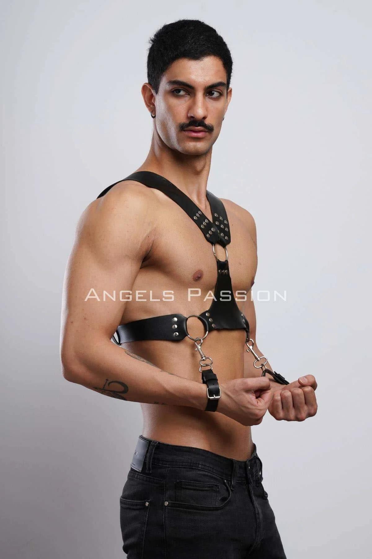 Full front view of mens black faux leather chest harness with three O-rings and wrist cuffs against neutral background
