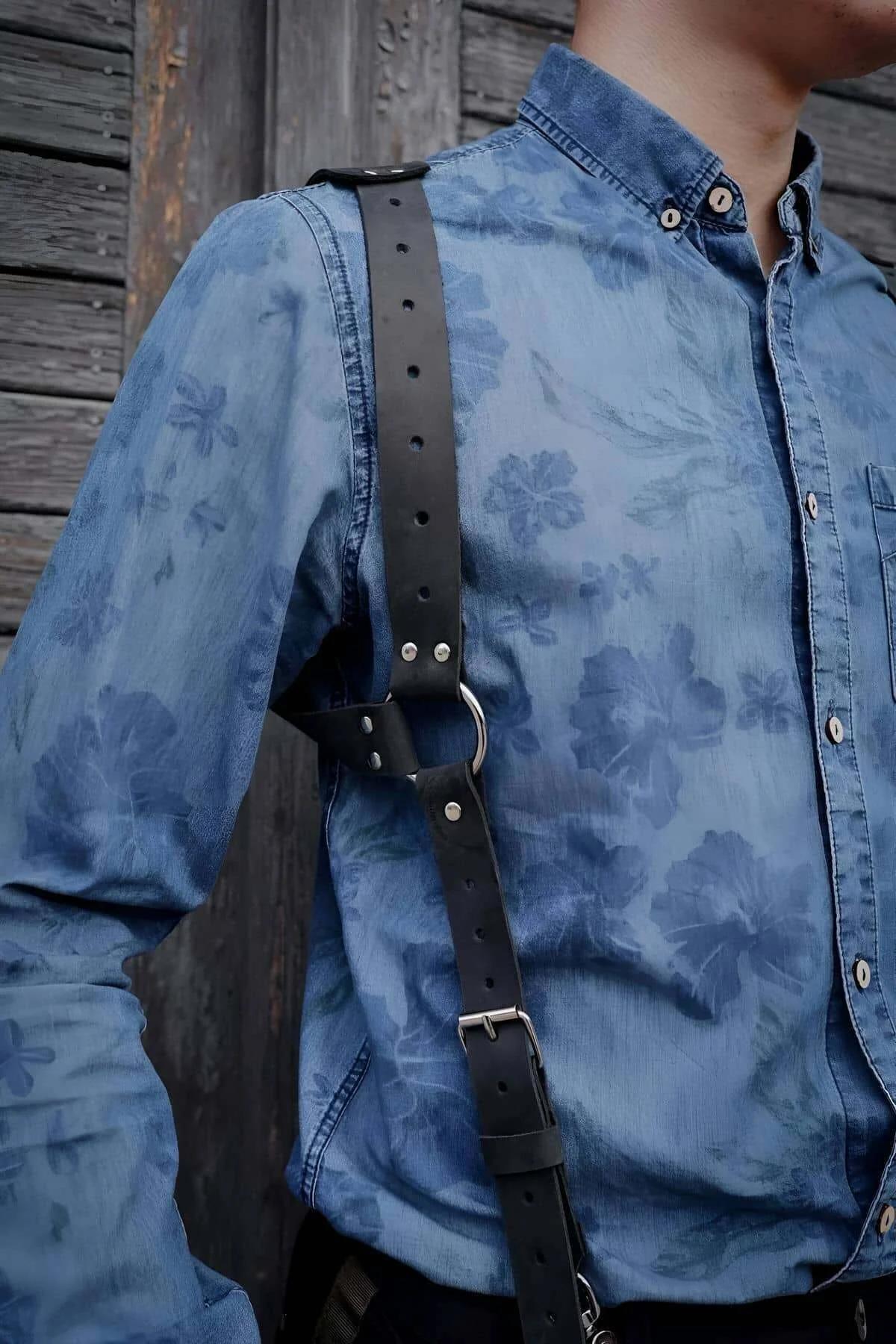 Adjustable black faux leather chest harness showing silver rivet details at strap junction points