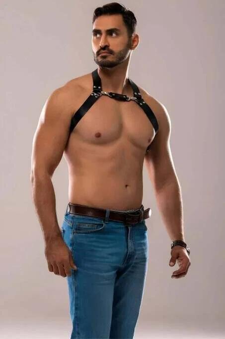 close-up of silver O-ring and metal snap buckles on black faux leather chest harness straps