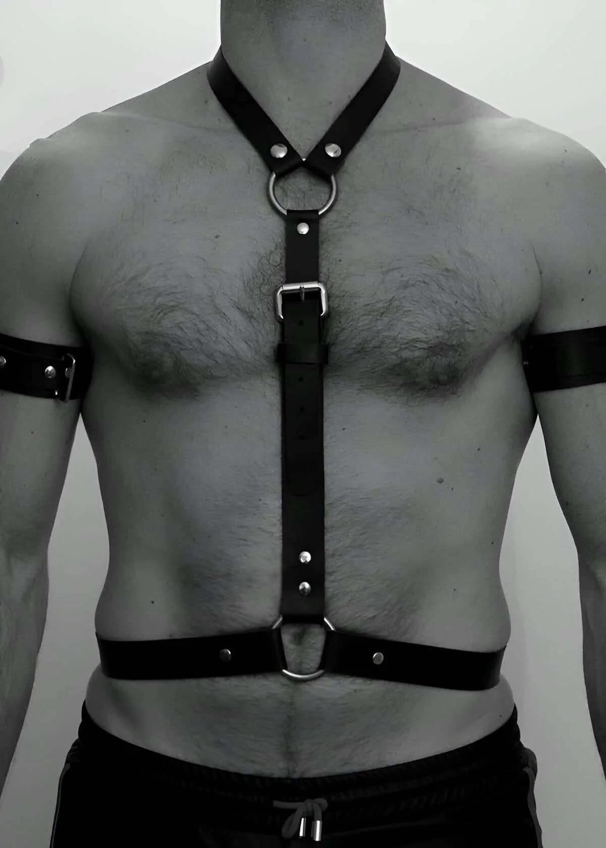 close-up of silver rectangular buckle on black faux leather chest harness strap