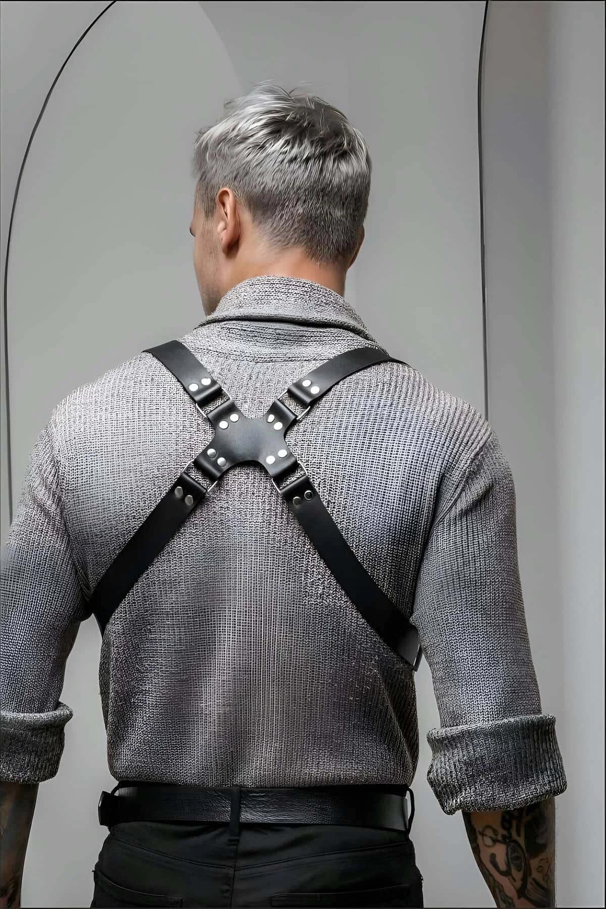 close-up of dark gunmetal rectangular buckle clasps on black faux leather chest harness straps