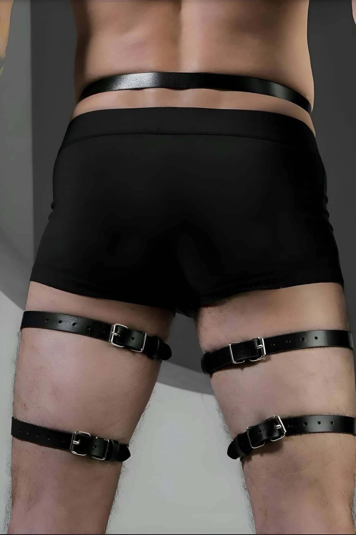 Close-up of silver O-ring and rivet detail on black faux leather leg harness strap