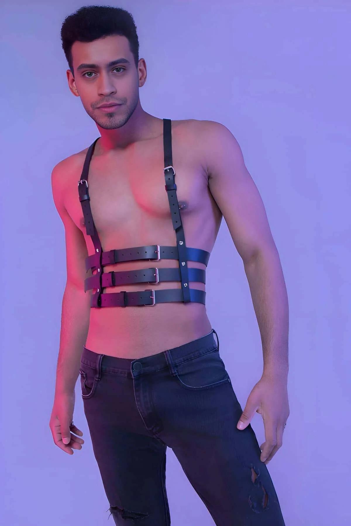 Close-up of silver-tone rectangular pin buckles on black faux leather waist straps of mens body harness