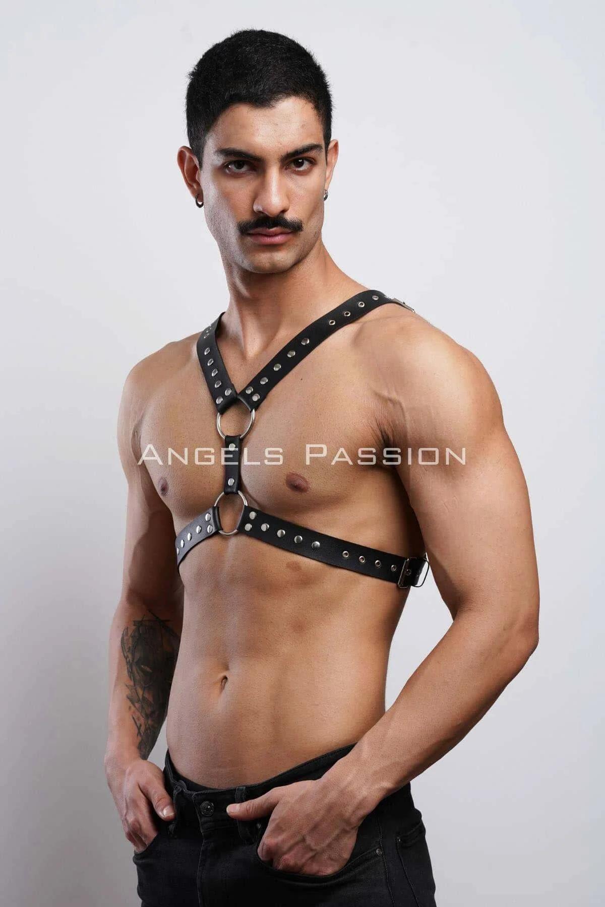 close-up of silver dome studs and O-ring detail on black faux leather chest harness strap