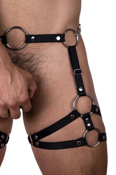 Close-up of silver O-ring junction with rivet studs on black vegan leather strap harness
