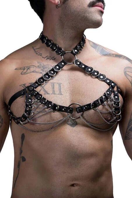 Close-up of silver dome studs and draped chain swags on black faux leather harness straps