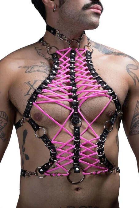 Close-up of neon pink elastic lacing woven in X-pattern across black faux leather chest harness