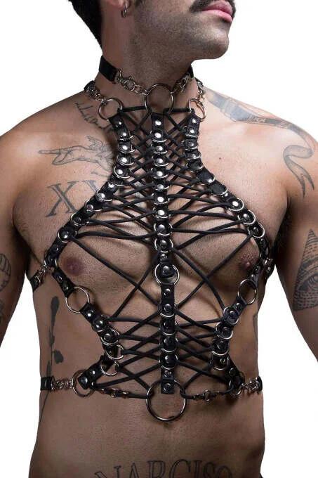Close-up of silver O-rings and criss-cross faux leather lacing on black men's body harness